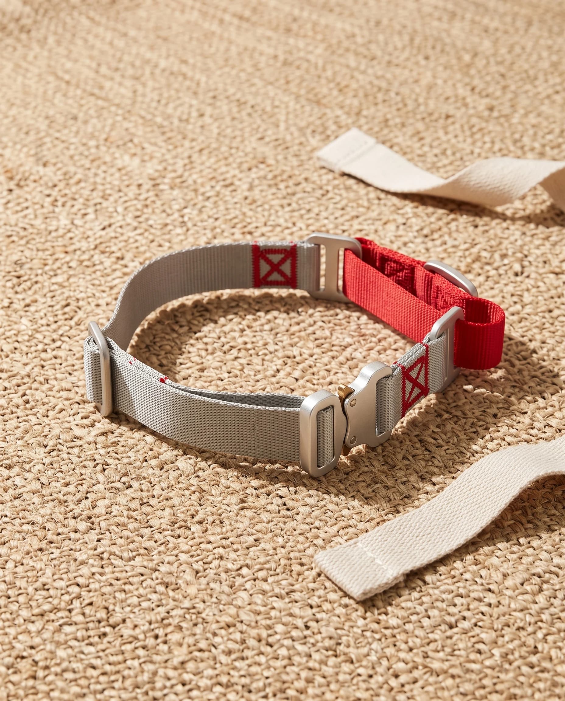 Field Collar in red on a round jute mat, silver-grey webbing with the red trim and aluminium cobra buckle