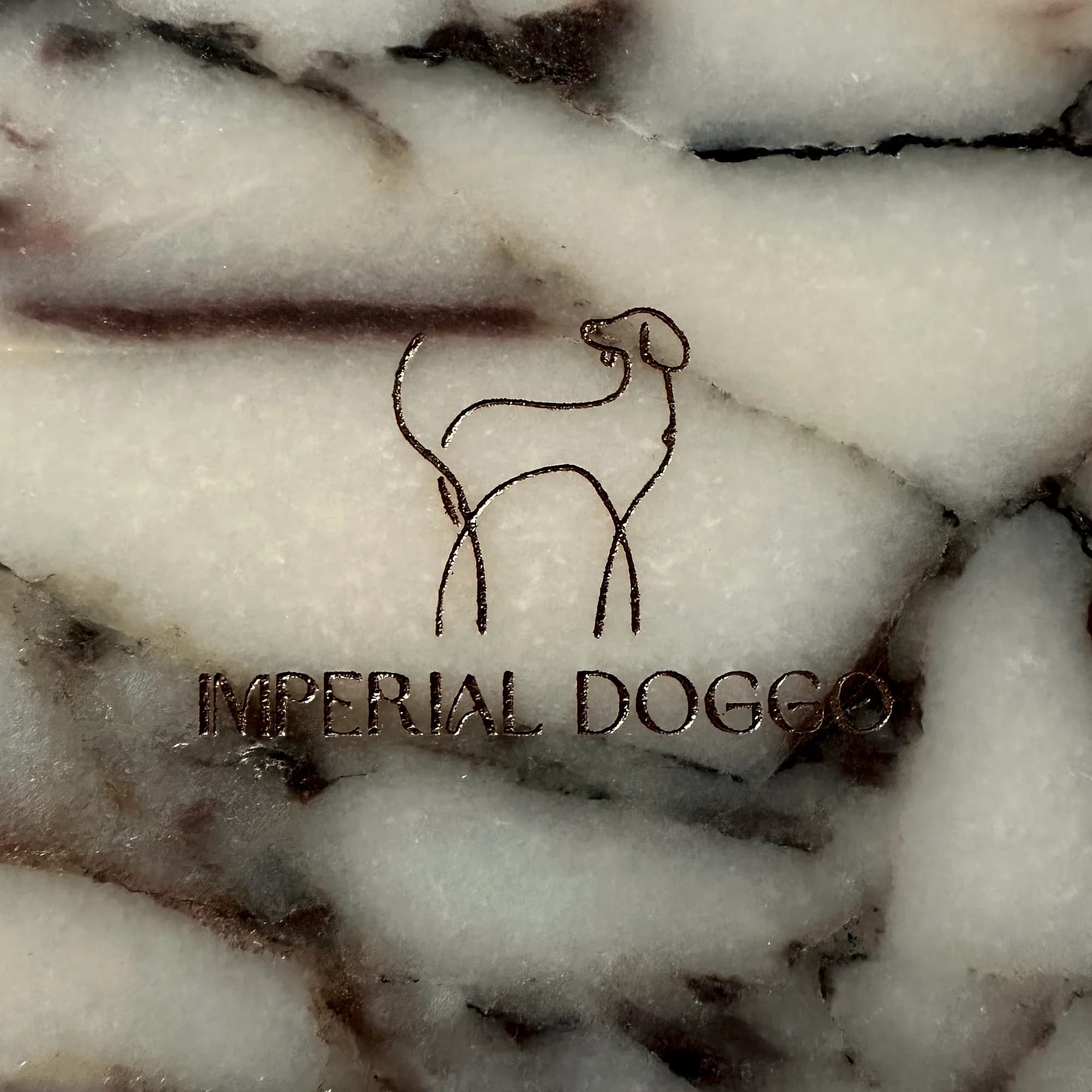 Underside of the Calacatta Viola bowl, engraved with the Imperial Doggo hound and wordmark