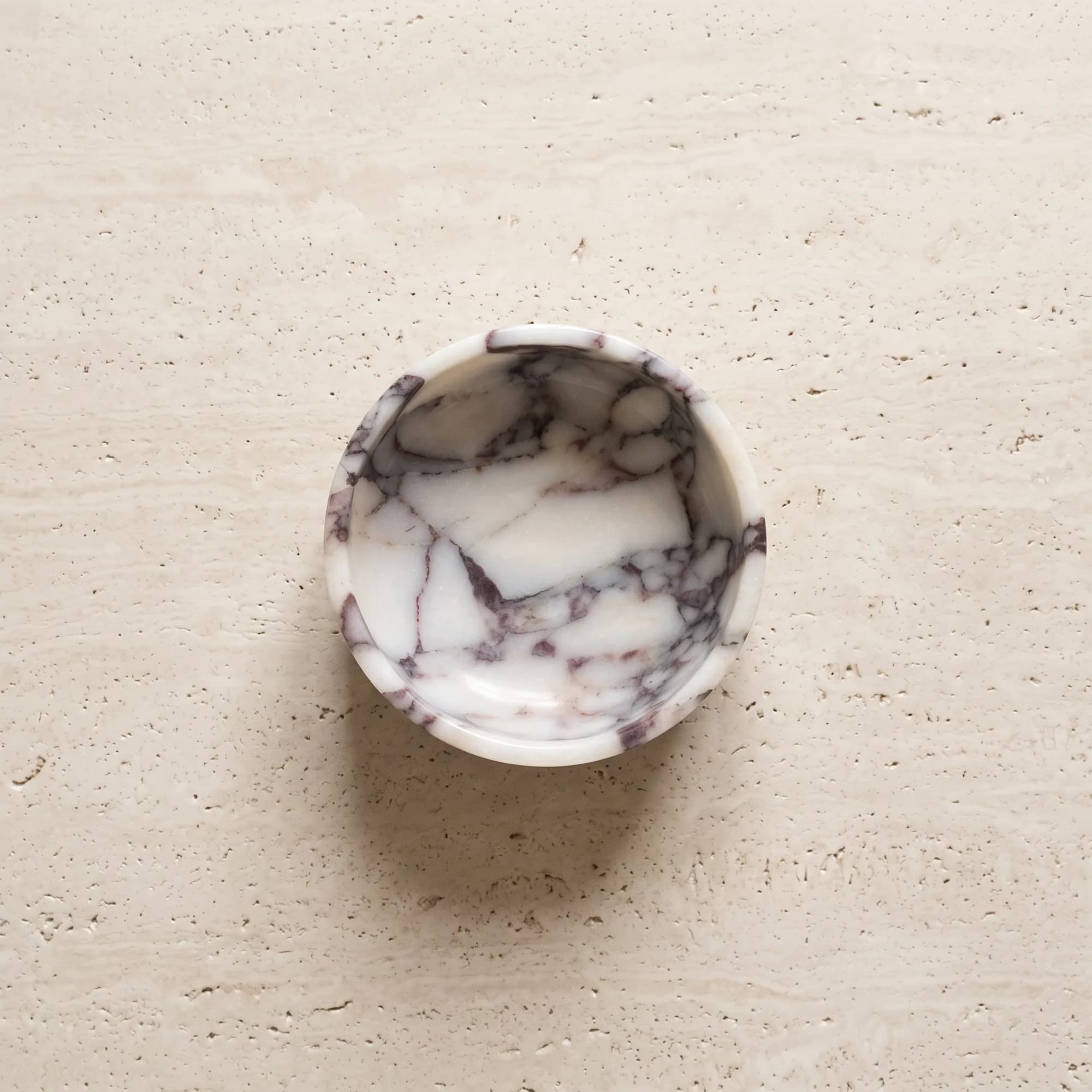 The Calacatta Viola bowl from above, violet veining across the white stone
